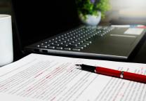 Des documents sont corrigés avec un stylo rouge